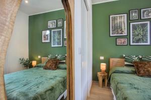 维亚雷焦VERSILIA MIA - beach at 8min by walk - new rooms!的一间卧室设有两张带绿色墙壁和镜子的床