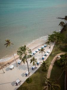 湄南海滩Napasai, A Belmond Hotel, Koh Samui的享有棕榈树和遮阳伞海滩的空中景致