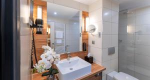 不莱梅PLAZA Premium Columbus Bremen的白色的浴室设有水槽和镜子