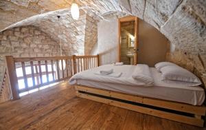 拜特龙Old Town Guesthouses的卧室配有一张石墙内的大床