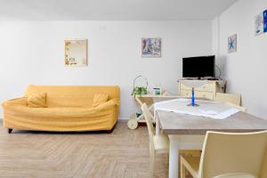 西尼斯科拉Appartamento Caterina的客厅配有桌子和黄色沙发