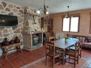 纳瓦伦加Casa Rural El Pajar Navaluenga的客厅配有桌子和壁炉