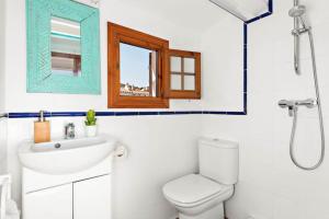 福尔内利斯Sunset Tirant的一间带水槽和卫生间的浴室以及窗户。