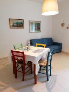 圣温琴佐Monica appartamenti的一张带椅子的餐桌和一张蓝色的沙发