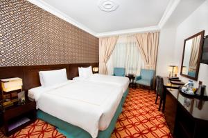 麦地那达拉泰巴酒店的酒店客房设有一张白色大床和一张书桌