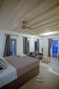 米克诺斯城Villabellum Mykonos的一间卧室配有一张床,客厅配有沙发
