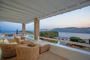 米克诺斯城Villabellum Mykonos的阳台配有藤椅,享有海景。