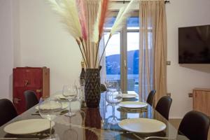 米克诺斯城Villabellum Mykonos的用餐室配有带酒杯的桌子