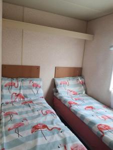 博尔斯克Wieczorne Mgły的卧室内的两张床,配有粉红色的火烈鸟