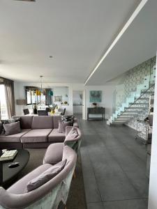 福斯DÚPLEX DE LUJO EN FOZ CON VISTAS al MAR的客厅设有两张沙发和一个楼梯