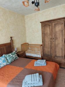 纳瓦伦加Casa Rural El Pajar Navaluenga的一间卧室配有两张单人床和一张婴儿床。