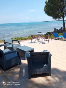 沃尔沃罗Studios Efi beach的一组椅子和桌子,靠近海洋