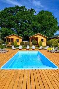 波波林Zielona Trawa的一个带木甲板和房子的游泳池