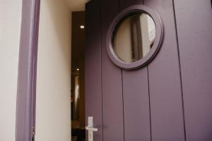 阿尔弗斯顿The Old Brewery, Ulverston的紫色的门,上面有一面圆镜子