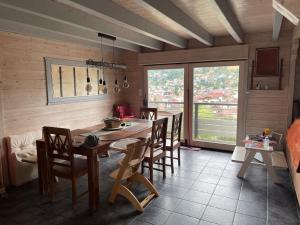 热拉梅Le chalet blanc de Gerardmer avec Spa的厨房配有大型木桌和椅子