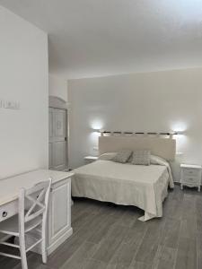 西尼斯科拉Sa Jacca Albergo Rurale的白色卧室配有床和书桌