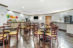 堪萨斯城堪萨斯城国际机场品质酒店的一间带木椅和桌子的餐厅以及柜台
