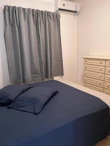 马约城Wave Maze的一间卧室设有蓝色的床和窗户。