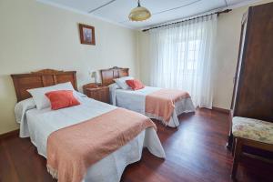 纳维亚Casa Choureiro Apartamentos Rurales的酒店客房设有两张床和窗户。