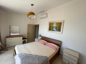 萨兰达布干维尔岛湾公寓的一间卧室配有一张床、梳妆台和镜子