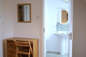 克洛纳基尔蒂Long Quay Apartments, Clonakilty的一间带水槽、书桌和镜子的浴室