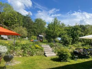 萨加尔德Ferienhaus-Fiete的一个带小径和橙色伞的花园