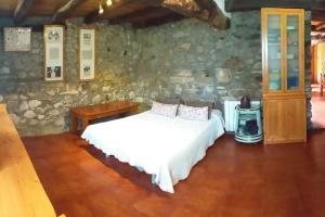蒙希亚Descanso en Burgozarre的一间卧室设有一张床和石墙