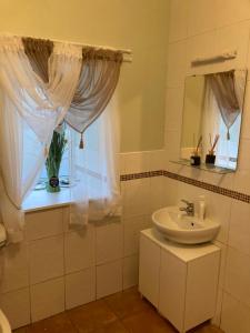 利特里姆Clinton’s cottage的白色的浴室设有水槽和窗户。