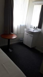 谢伊伦德旅客车站酒店的一间带水槽、桌子和窗户的浴室