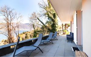 GambarognoCasa AmaRe - einzeln stehendes Haus mit spektakulärer Aussicht的阳台配有椅子,享有水景