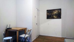 Llwyn-y-piaLlewellyn House的一间设有书桌的客房,墙上挂有绘画作品