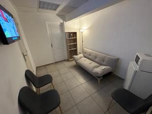 圣丹尼斯AZUR HOTEL的客厅配有沙发、椅子和电视