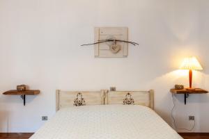 San RomanoDolce far niente的一间卧室配有一张床、一盏灯和闹钟