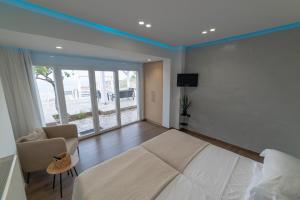 阿齐亚佩拉加"BlueVedere" Sea View Luxury Villa的一间卧室配有一张床、一张沙发和一台电视。