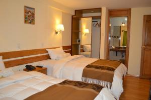 库斯科Florida del Inca Hotel的酒店客房,设有两张床和镜子