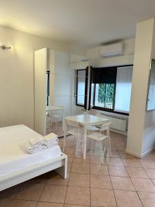 米兰Easy Milano Apartment Navigli的客房设有2张桌子和椅子以及窗户。