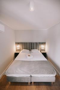 托伦Między Murami的一间卧室配有一张带白色床单的大床
