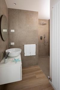 里乔内The Palm Riccione的浴室设有白色水槽和镜子