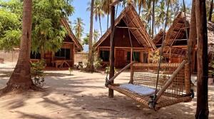 帕杰Your Zanzibar Place的棕榈树屋前的吊床