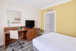 查塔姆罗切斯特查塔姆酒店的酒店客房配有一张床、一张书桌和一台电视。