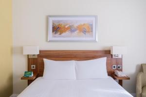 查塔姆罗切斯特查塔姆酒店的卧室配有白色的床和椅子