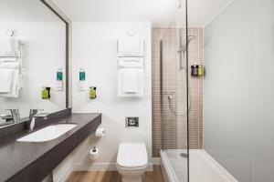 查塔姆罗切斯特查塔姆酒店的浴室配有卫生间、盥洗盆和淋浴。