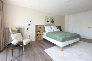 波鸿80qm Luxuriöse Designerwohnung im Herzen Bochums的一间卧室配有一张床和一把椅子