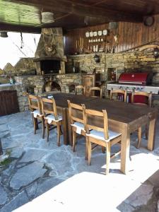 阿普里尔齐Къща за гости КИМ的木桌和椅子以及石制壁炉