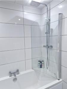 汉密尔顿Flat in Hamilton, South Lanarkshire的白色瓷砖浴室内的淋浴