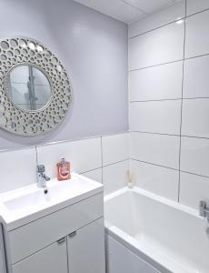 汉密尔顿Flat in Hamilton, South Lanarkshire的白色的浴室设有水槽和镜子