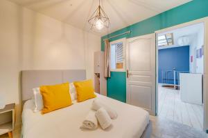 波尔多Le 22 - Magnifique appartement en plein cœur des Chartrons的卧室配有一张带黄色枕头的大型白色床。