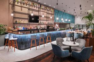 霍利伦敦盖特威克机场万怡酒店的餐厅内的酒吧配有椅子和柜台