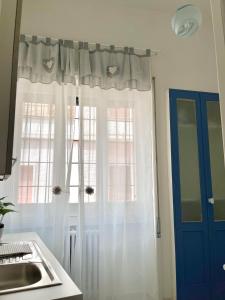 加拉蒂纳House fifty的厨房配有带白色窗帘和水槽的窗户。