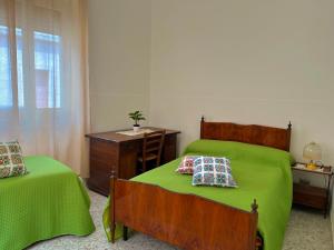 加拉蒂纳House fifty的一间卧室配有两张带绿床单的床和一张书桌